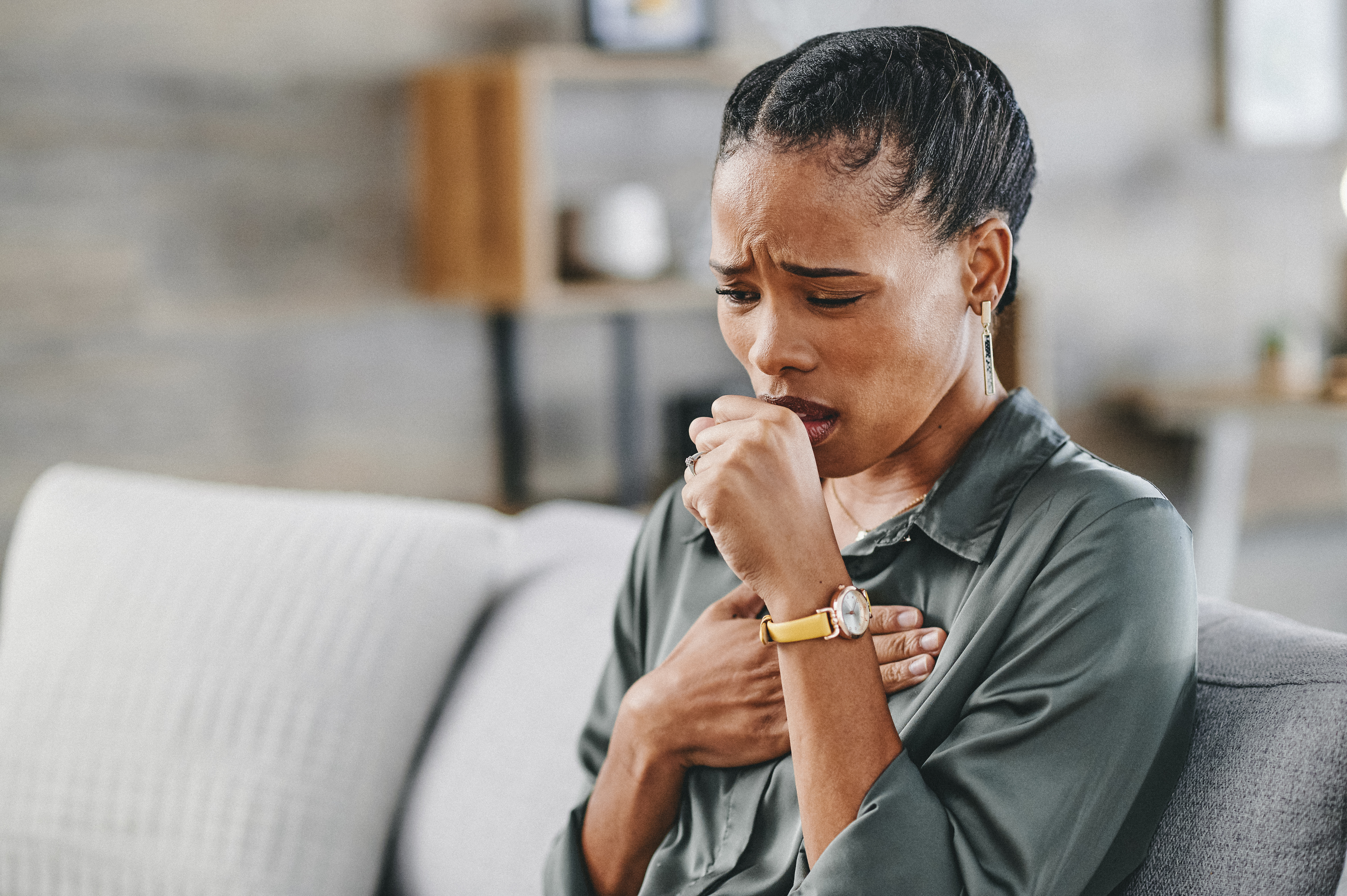 Woman coughs home on couch